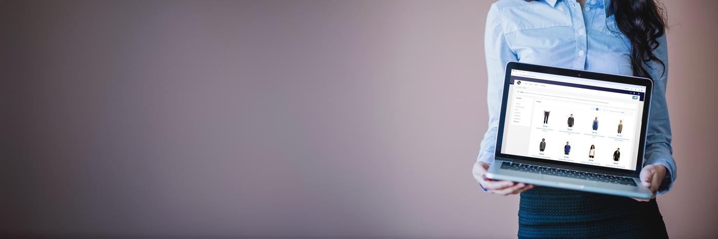 Person holding a laptop with a website displayed on a plain background