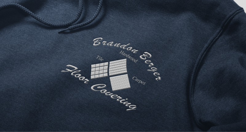 A navy-blue sweatshirt featuring an embroidered company logo on the left chest, exemplifying CCS Inc.'s professional embroidery services.